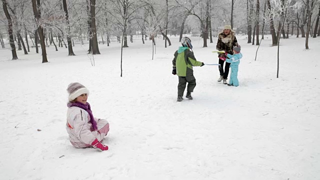孩子们和奶奶在雪地上玩得很开心视频素材