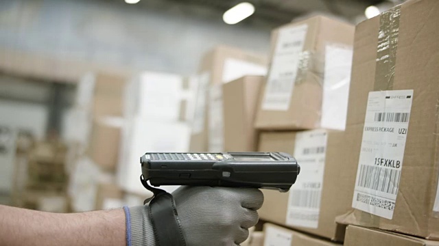 仓库员工手持扫描仪，扫描仓库中的包裹视频素材