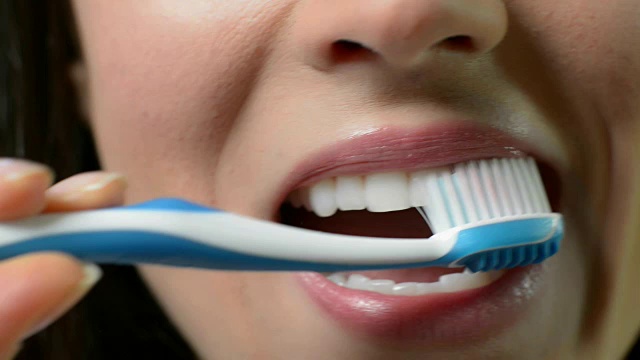 女人用手动牙刷刷牙的特写视频素材