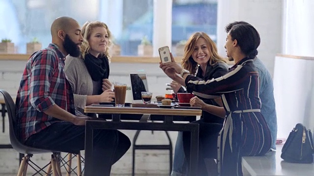 WS。桌子上的朋友聊天在当地的咖啡店和抓拍的饮料与智能手机。视频素材