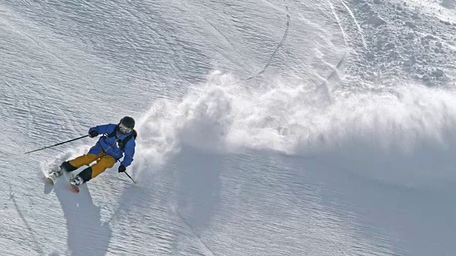 SLO MO野外滑雪者滑雪下山阳光照耀的山顶视频购买