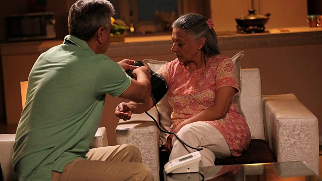 印度德里，一位老人正在给妻子测血压视频素材