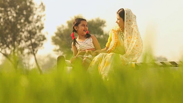 印度哈里亚纳邦，一名成年妇女在农场和女儿玩耍视频素材