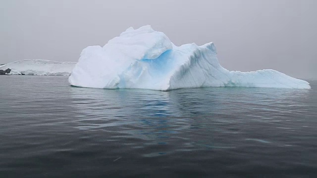 南极半岛，杰拉什海峡，一座蓝色的冰山漂浮在水面上，从黄道带上看视频下载