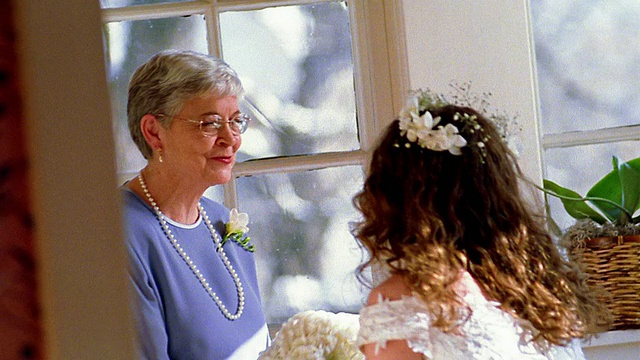 中镜头新娘捧着花束亲吻母亲的脸颊/跪在母亲面前视频下载