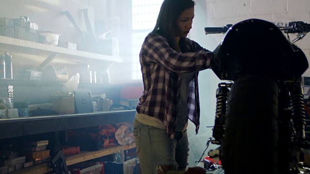 女汽修店机械师抛光和电线摩托车。视频素材