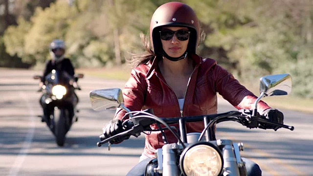 女人们骑着摩托车在阳光明媚的高速公路上游弋。视频下载