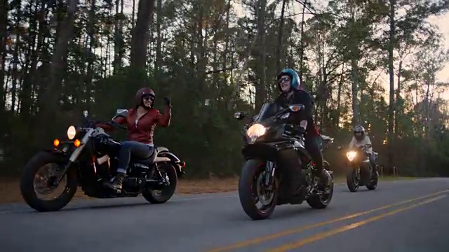 三个骑摩托车的女性朋友在森林里互相嘲笑。视频素材