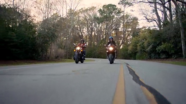 两个朋友骑着摩托车在空旷的高速公路上玩。视频素材