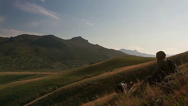 全景图中有山脉和一个正在休息的女人和一只狗视频下载
