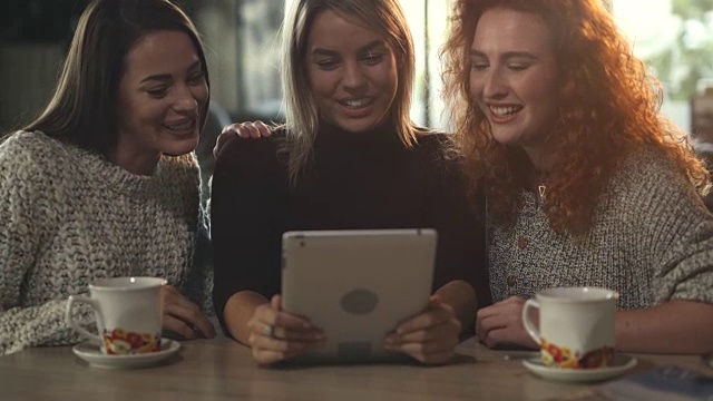 在触摸板上上网和在咖啡馆里交流的快乐女人。视频素材