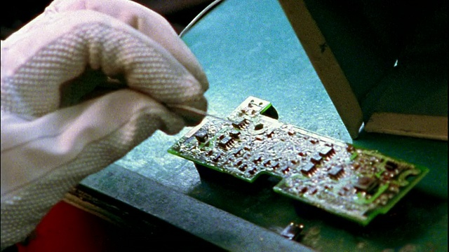 合上戴手套的手检查电脑芯片板/焊接电脑芯片板视频素材