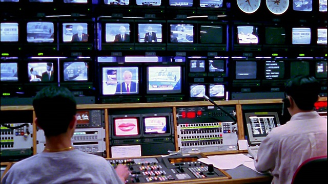 中景拍摄的工人坐在电视广播控制室CNBC亚洲局/香港视频素材