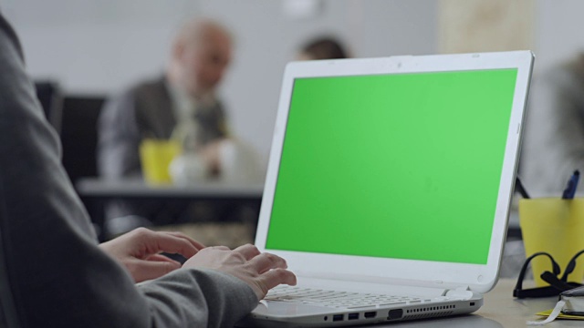 女性用绿色屏幕在笔记本电脑上打字视频下载
