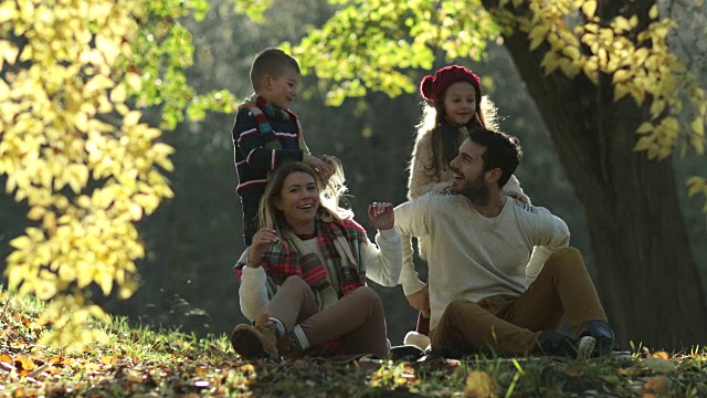 玩耍的孩子和他们的父母在一个秋天的一天在大自然中玩耍。视频素材