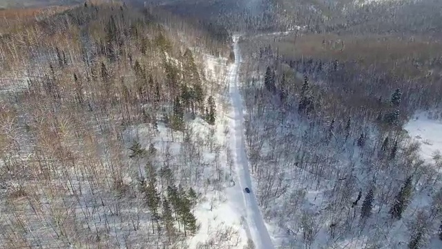 无人机拍摄的汽车在被雪封的道路上漂移和超速视频素材