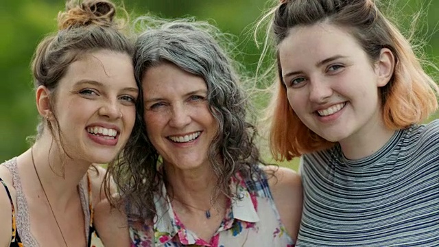 母亲和两个女儿在镜头前微笑和大笑的肖像。视频素材