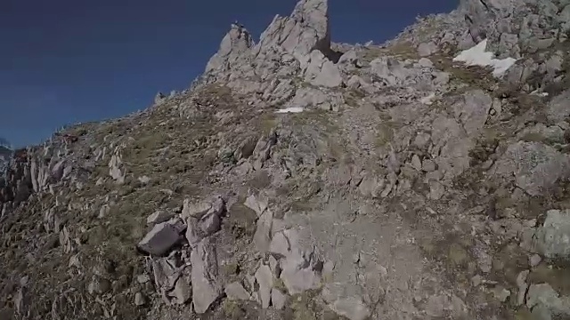速度无人机视角的登山者攀登一个高山峰的顶峰视频素材