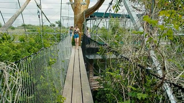 WS SLO MO:母亲和女儿走过树梢桥。视频素材