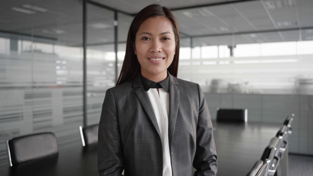 SLO MO Asian businesswoman smiling into the camera while standing in the conference room视频素材