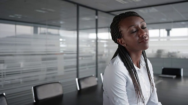 一个微笑的非裔美国女商人的肖像在一个空的会议室视频素材