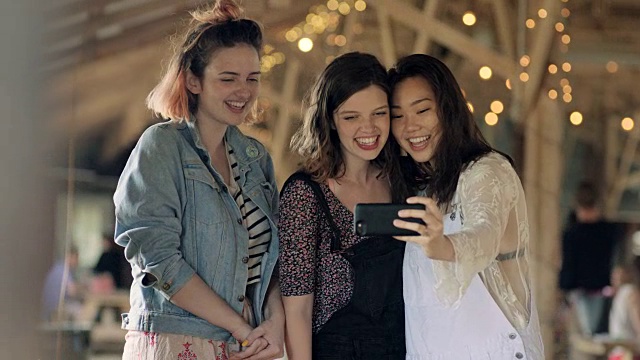 三名女孩在奥斯汀乡村餐厅用智能手机自拍。视频素材