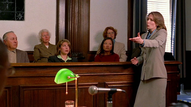 中镜头的女律师与前景中的陪审团/对方律师交谈视频下载
