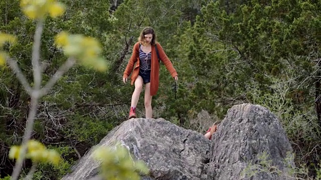 徒步旅行的女孩伸出手帮助姐姐爬上山顶。视频素材