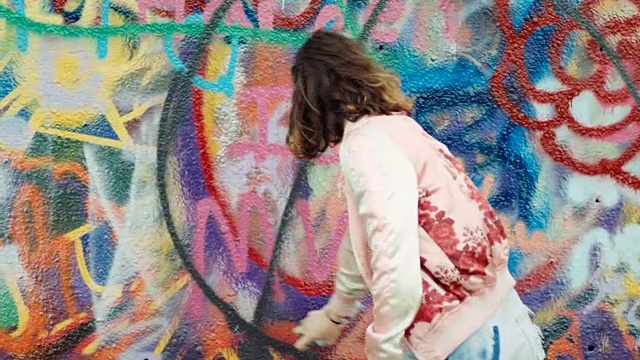 MS. Girl用喷漆在涂鸦墙上做设计。视频下载