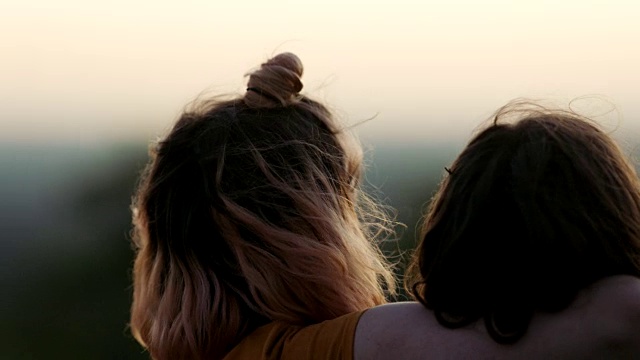 日落时分，两姐妹在田野里拥抱。视频素材