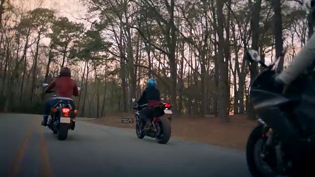 三名女子骑着摩托车穿越州立公园森林进行公路探险。视频素材