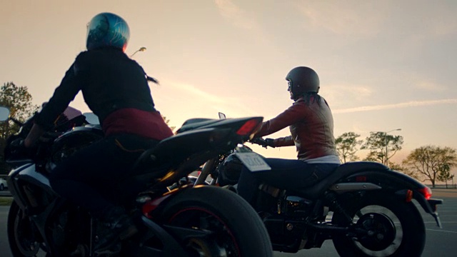SLO MO，两个女人骑着摩托车从停车场出来。视频素材