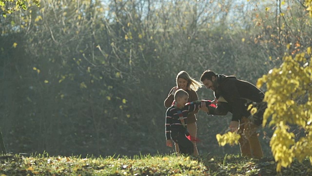 好玩的家庭追逐在自然和有乐趣的秋天的一天。视频素材