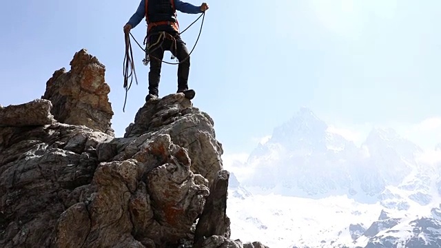 男登山家向队友扔绳子，山视频素材