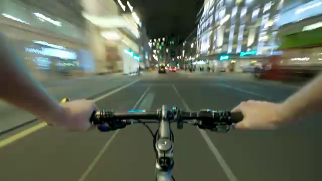 一名骑自行车的人在夜间快速穿过伦敦西区，经过特拉法加广场，然后沿着威斯敏斯特前往议会大厦视频下载