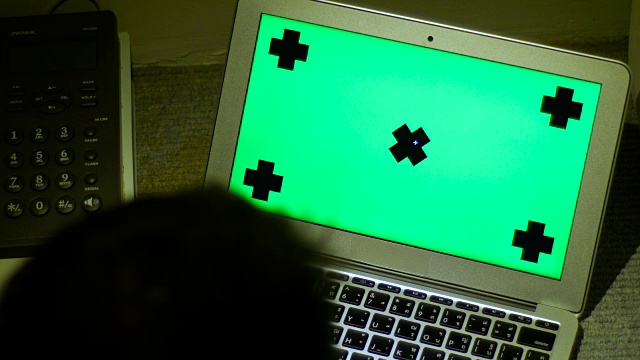 一名男子晚上在家庭办公室使用绿屏笔记本电脑视频素材