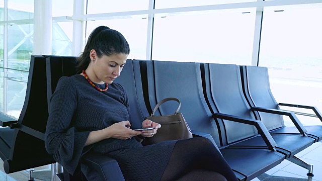 一名女子在机场使用手机。视频素材