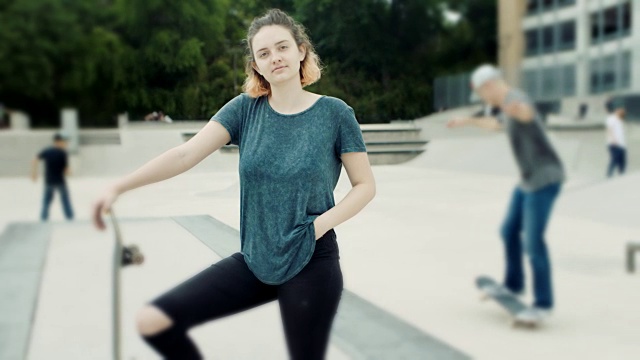 WS SLO MO.女孩与滑板在城市滑板公园摆姿势的肖像。视频素材