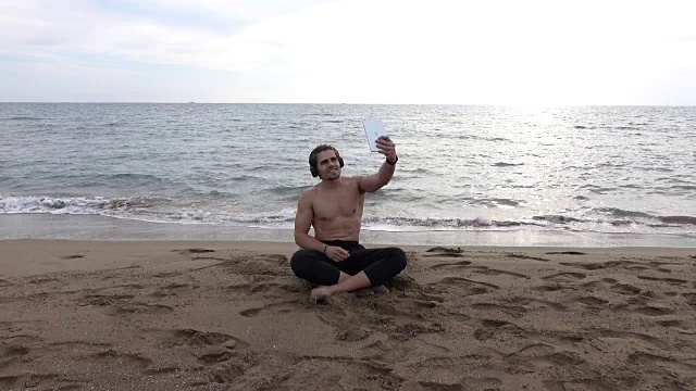 英俊的男人独自在海滩上休息视频下载