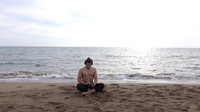 英俊的男人独自在海滩上休息视频下载