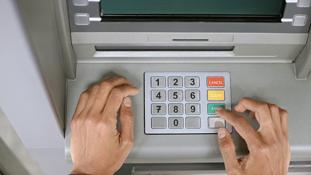 在ATM机输入密码时，女性的手挡住了键盘视频素材