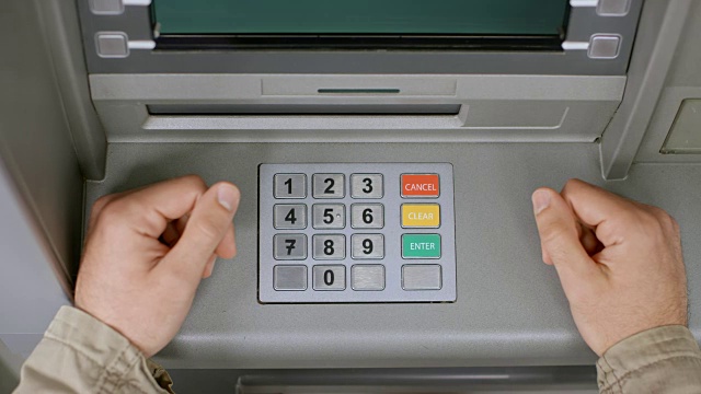 男性的手插入一张银行卡，并在ATM机的键盘上输入密码视频下载