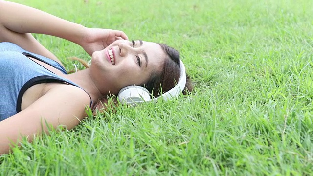 女运动员在草地上享受音乐视频素材