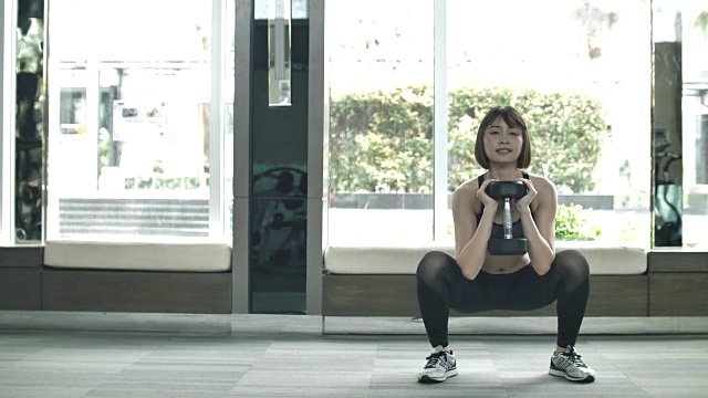 运动女性在健身房用哑铃锻炼视频素材