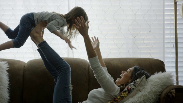 母亲和女儿在沙发上玩耍的中景/美国犹他州普罗沃视频素材