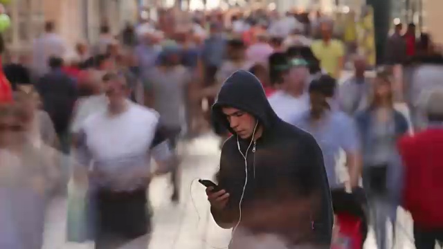 一个年轻人独自在繁忙的街道上视频下载