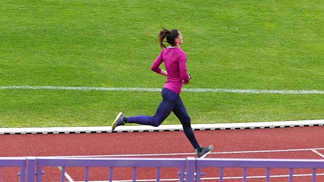 年轻的女运动员在跑道上训练慢动作录像视频下载