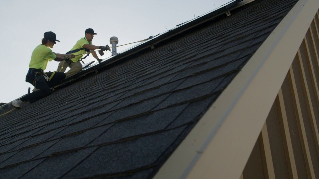 工人在屋顶安装太阳能电池板的宽平移低角度拍摄/美国犹他州梅普尔顿视频素材