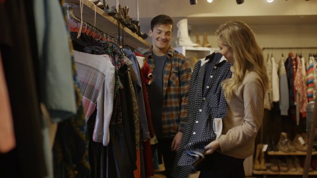 中等镜头的男人看女人购买复古服装/普罗沃，犹他州，美国视频下载