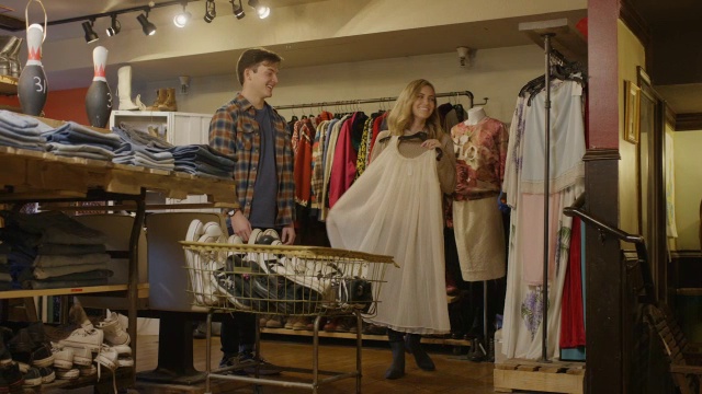 中等镜头的男人看女人购买复古服装/普罗沃，犹他州，美国视频下载